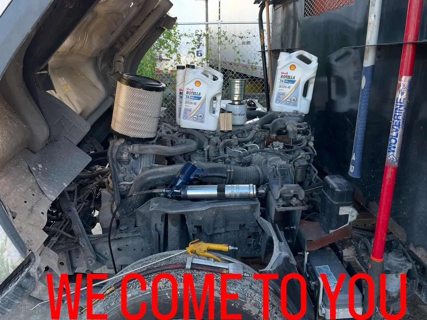 Client oil change setup: filters, oil, and other supplies in truck engine bay